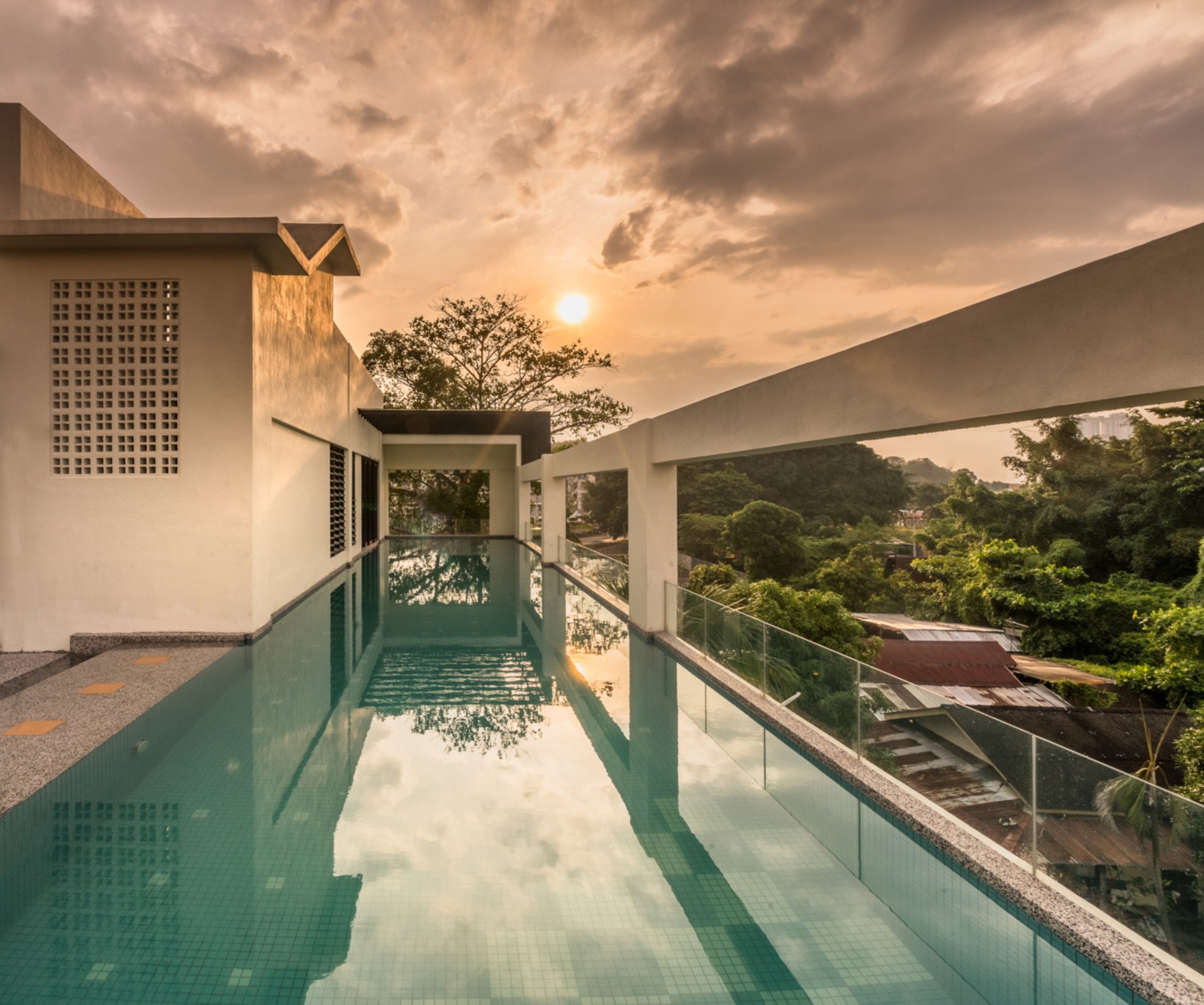 Rooftop infinity pool with sun loungers and glass balustrade